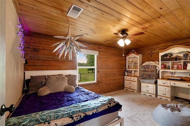 bedroom with visible vents, wood walls, ceiling fan, wood ceiling, and carpet flooring