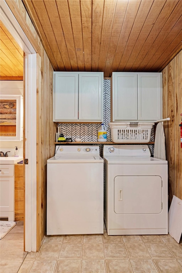 laundry room featuring cabinet space, independent washer and dryer, a sink, wood walls, and wooden ceiling