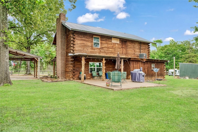 back of property with log exterior, a carport, a chimney, a lawn, and a patio