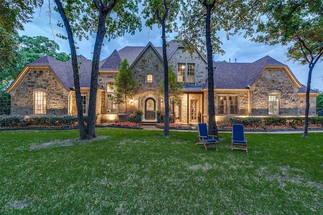 view of front of house with a front yard and stone siding