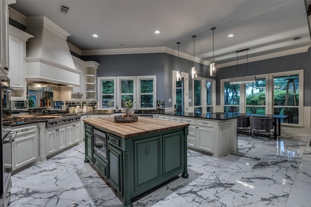 kitchen with wood counters, stainless steel appliances, visible vents, custom exhaust hood, and green cabinets