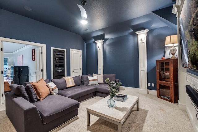 living room featuring carpet flooring, decorative columns, and vaulted ceiling
