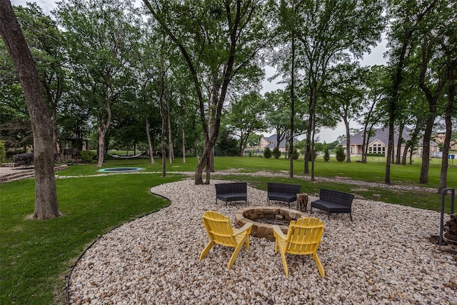 view of home's community featuring a lawn and an outdoor fire pit