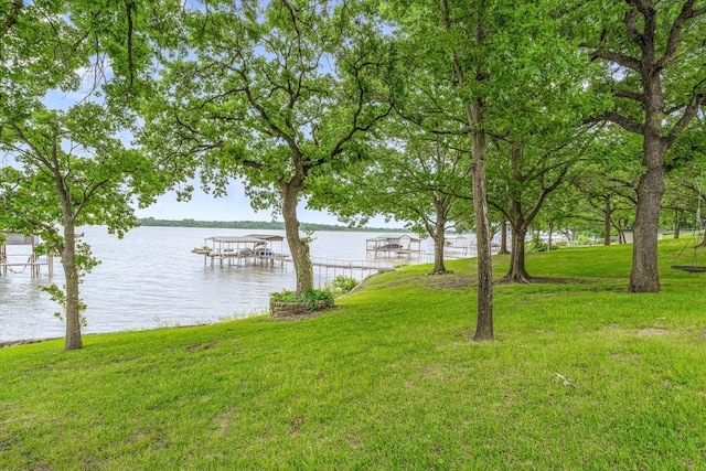 view of yard featuring boat lift, a boat dock, and a water view
