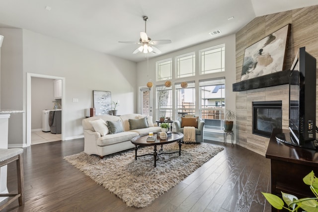 1101 Helmsley Dr, Frisco, TX 75036 - living area featuring a high ceiling, a fireplace, a ceiling fan, wood finished floors, and visible vents