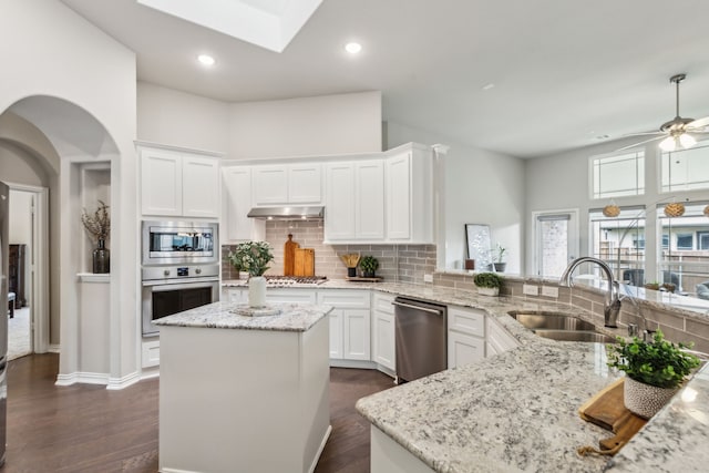 1101 Helmsley Dr, Frisco, TX 75036 - kitchen featuring dark wood-style flooring, a sink, stainless steel appliances, white cabinetry, and backsplash