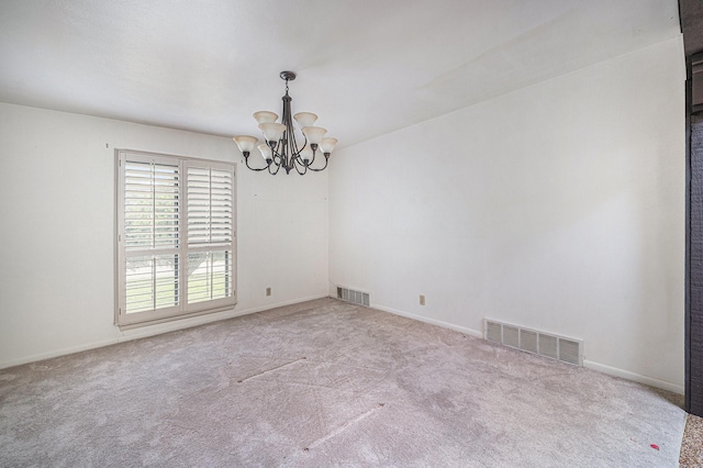 carpeted empty room featuring an inviting chandelier, baseboards, and visible vents