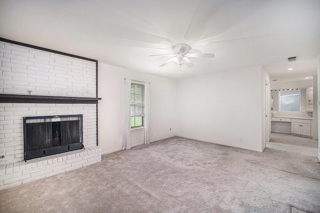 unfurnished living room with a ceiling fan, a brick fireplace, carpet floors, visible vents, and baseboards