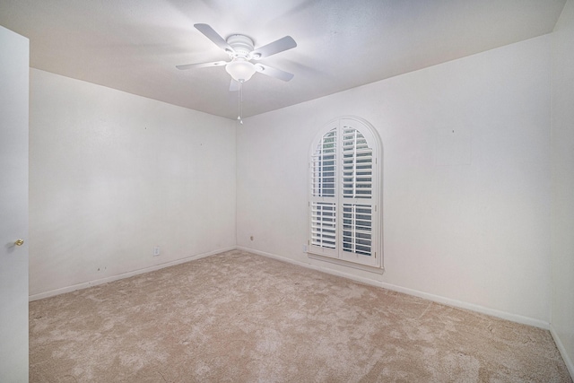 empty room with carpet flooring, baseboards, and ceiling fan
