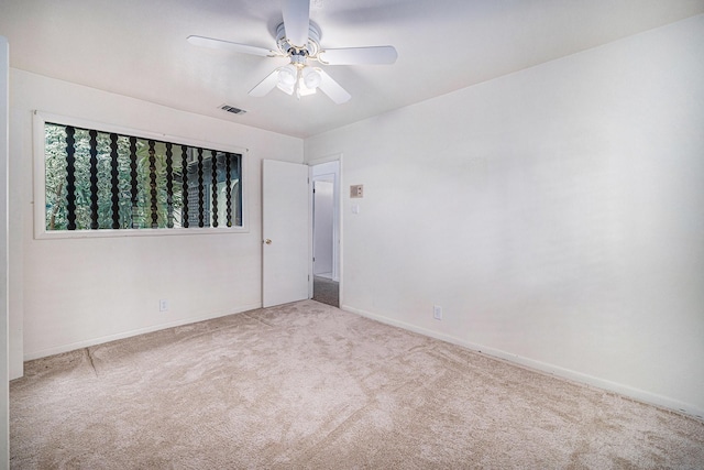 carpeted empty room featuring visible vents, baseboards, and ceiling fan