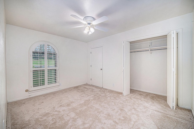 unfurnished bedroom with baseboards, carpet flooring, a closet, and ceiling fan