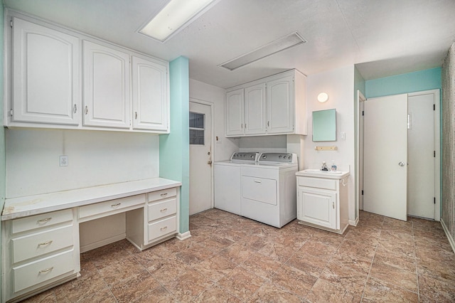 laundry area featuring separate washer and dryer, cabinet space, stone finish floor, and baseboards