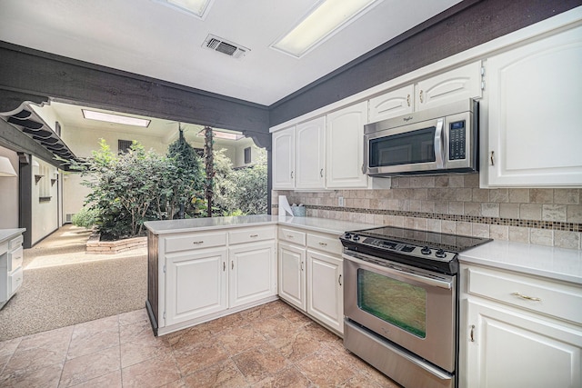 kitchen with stainless steel appliances, light countertops, visible vents, and white cabinets