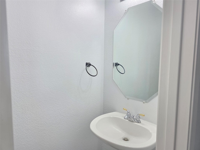 bathroom featuring a sink and a textured wall