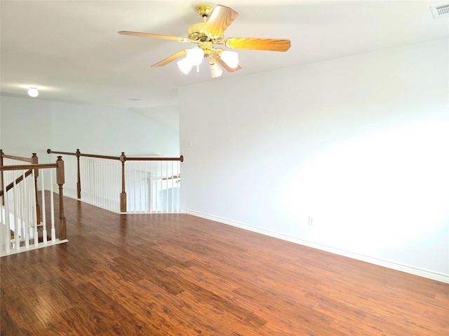 unfurnished room with baseboards, a ceiling fan, wood finished floors, and visible vents