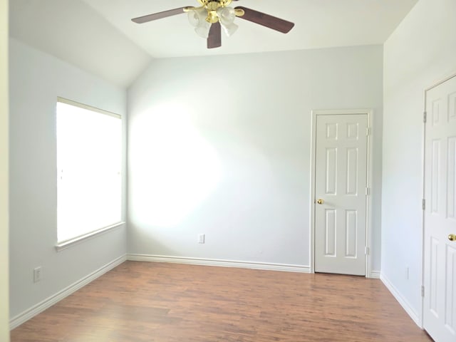unfurnished room featuring a ceiling fan, baseboards, wood finished floors, and lofted ceiling