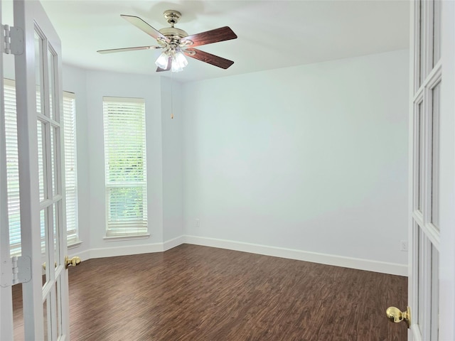 unfurnished room with baseboards, ceiling fan, and dark wood-style floors