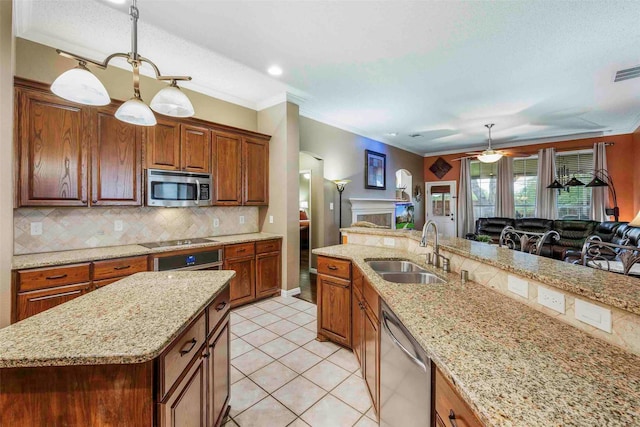 kitchen featuring backsplash, pendant lighting, a sink, open floor plan, and stainless steel appliances
