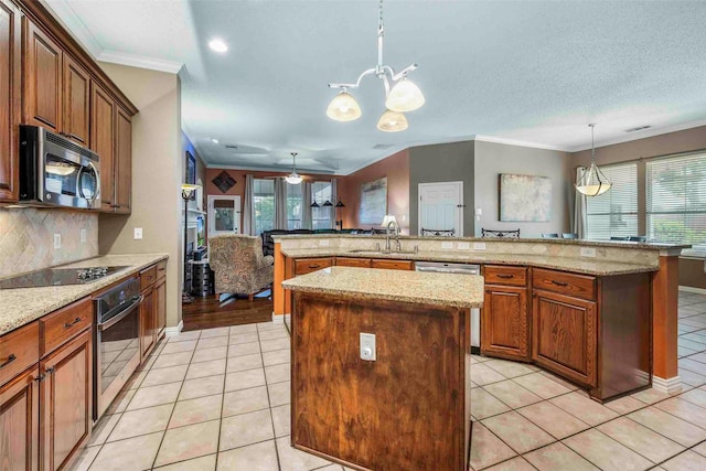 kitchen featuring a kitchen island, decorative light fixtures, appliances with stainless steel finishes, a sink, and ornamental molding