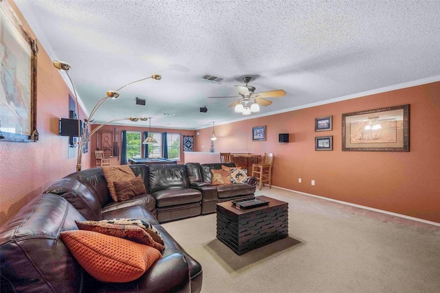 living area with ceiling fan, a textured ceiling, visible vents, crown molding, and baseboards