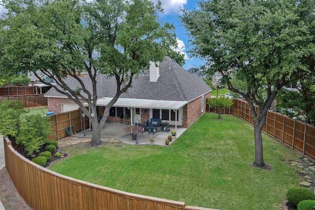 back of house with a shingled roof, brick siding, a fenced backyard, a patio, and a yard
