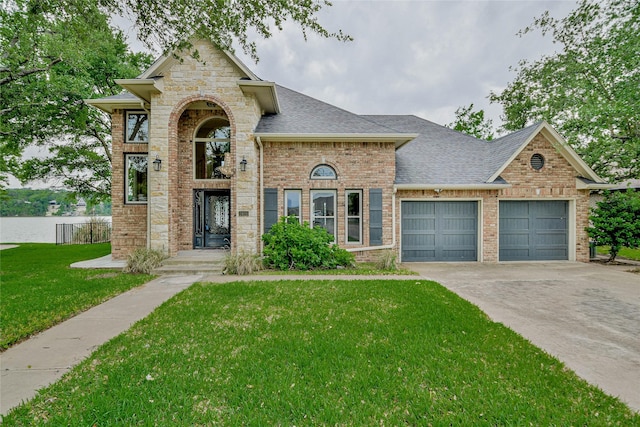 traditional-style home featuring a shingled roof, brick siding, a garage, a front yard, and driveway