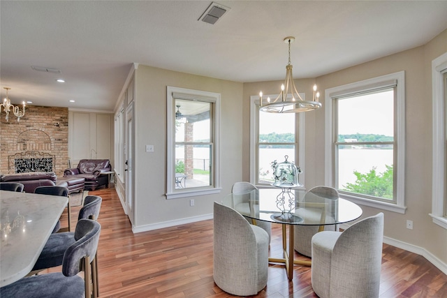 dining room with baseboards, an inviting chandelier, light wood-style flooring, and visible vents