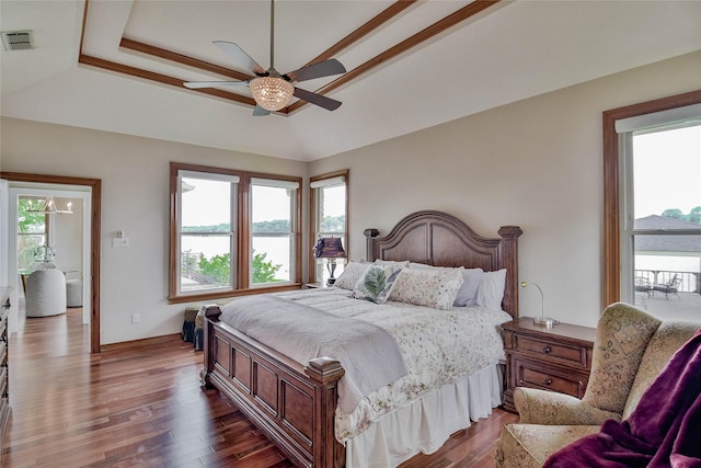 bedroom featuring ceiling fan, visible vents, a raised ceiling, a water view, and dark wood-type flooring
