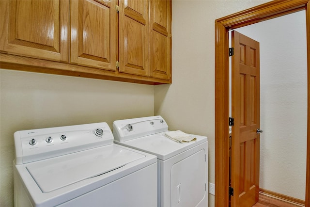 laundry room with cabinet space, baseboards, and washing machine and dryer