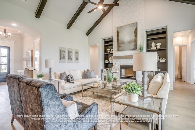 living area with beam ceiling, a fireplace, arched walkways, high vaulted ceiling, and built in shelves