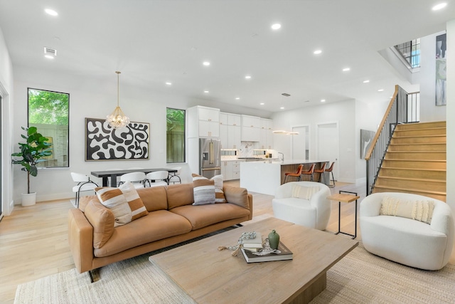 9409 Lenel Pl, Dallas, TX 75220 - living area featuring recessed lighting, stairs, light wood-style flooring, baseboards, and a chandelier