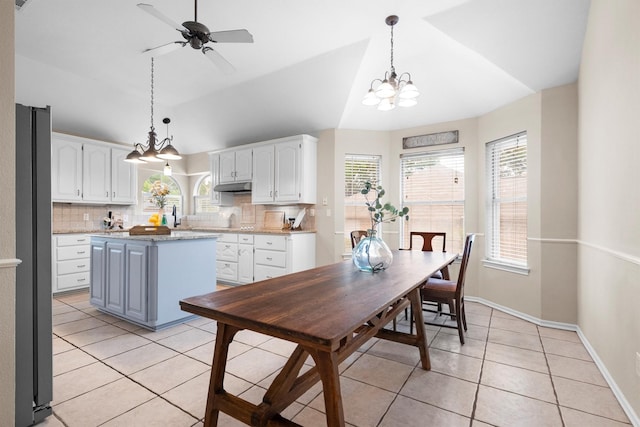 kitchen featuring light tile patterned floors, decorative backsplash, under cabinet range hood, and white cabinetry