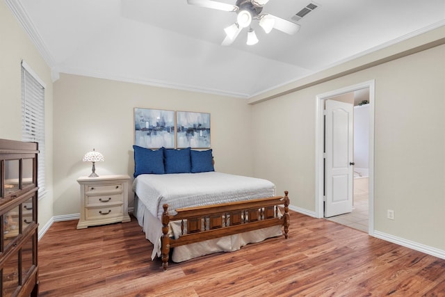 bedroom with crown molding, ensuite bathroom, wood finished floors, and visible vents