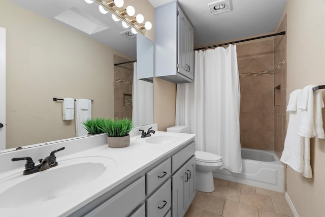 bathroom with a sink, tile patterned flooring, shower / bath combo with shower curtain, and toilet