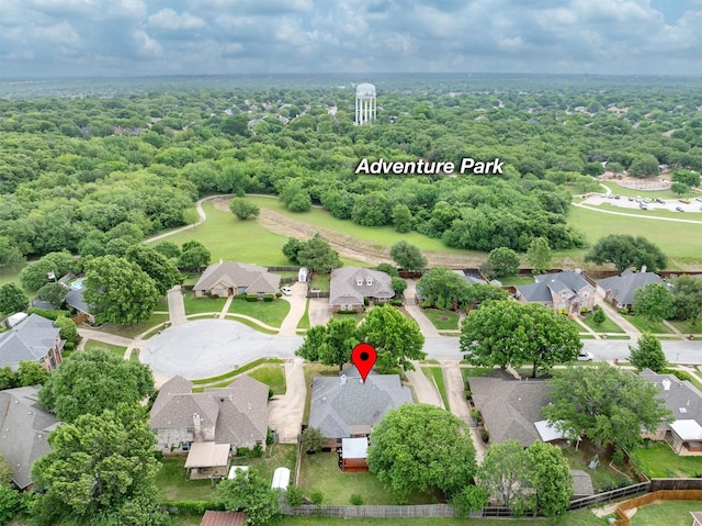 drone / aerial view featuring a residential view and a wooded view