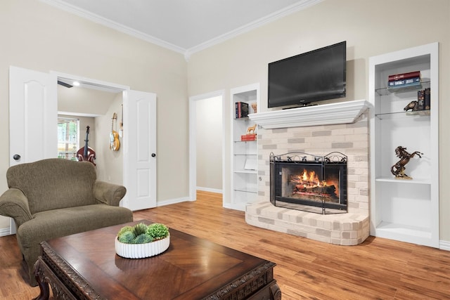 living room featuring baseboards, ornamental molding, a fireplace, and wood finished floors