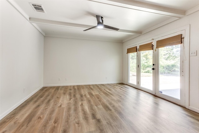spare room with a ceiling fan, visible vents, baseboards, beamed ceiling, and light wood finished floors