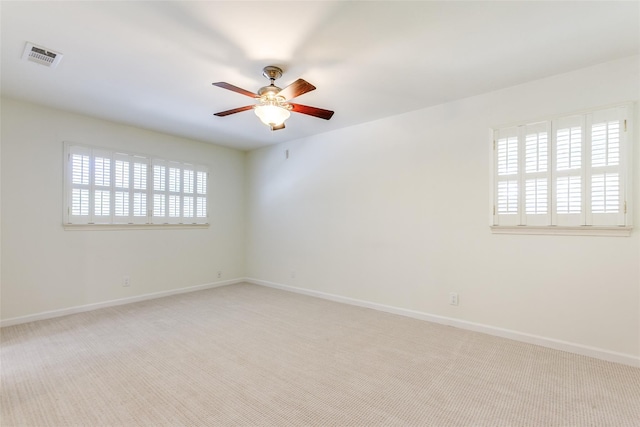 empty room with visible vents, a ceiling fan, baseboards, and carpet floors