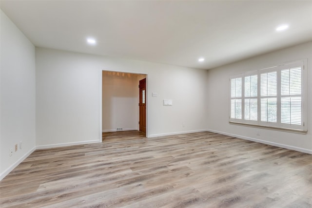 spare room with baseboards, light wood-type flooring, and recessed lighting