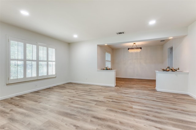 unfurnished living room featuring visible vents, baseboards, recessed lighting, light wood-type flooring, and a chandelier