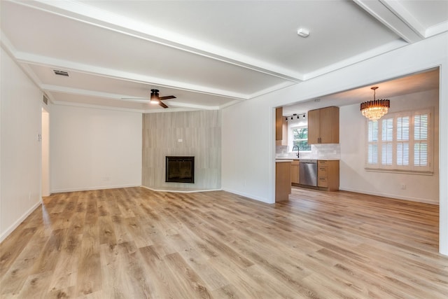 unfurnished living room with visible vents, beamed ceiling, baseboards, light wood-type flooring, and ceiling fan with notable chandelier