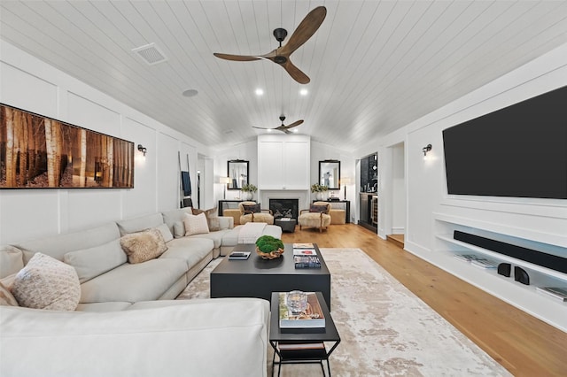 living room featuring ceiling fan, vaulted ceiling, built in shelves, wooden ceiling, and light wood finished floors