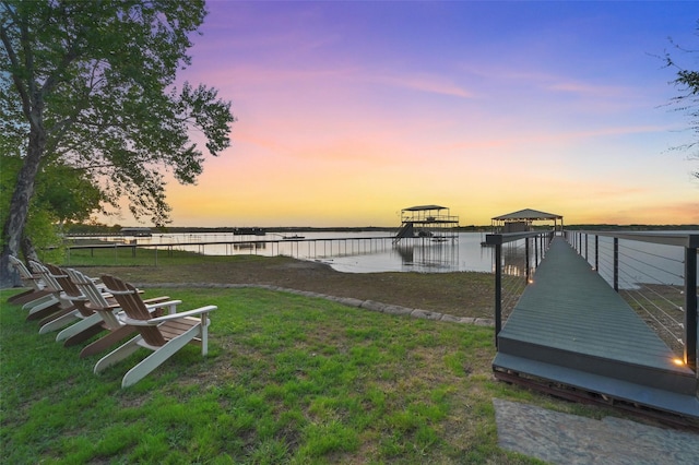 yard at dusk featuring a water view