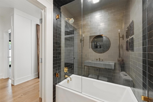 bathroom featuring shower / bath combination with glass door and wood finished floors
