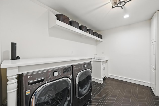 laundry room with baseboards, a sink, cabinet space, and washing machine and dryer