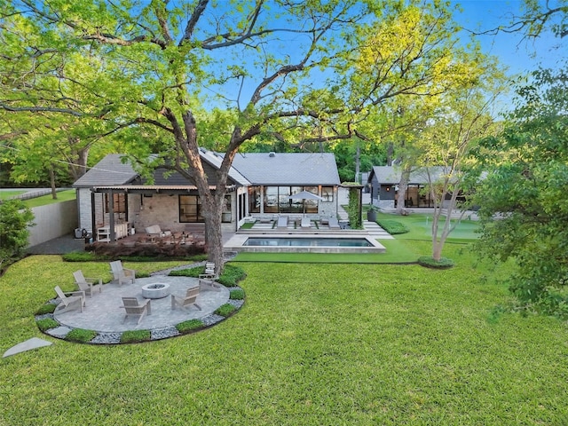 back of property with fence, an outdoor pool, a patio area, a lawn, and an outdoor fire pit