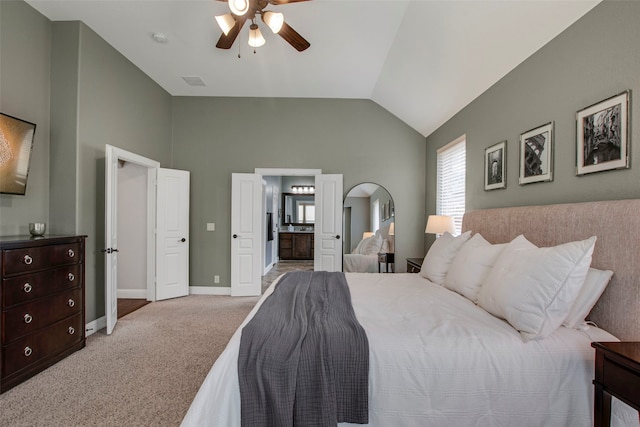 carpeted bedroom featuring a ceiling fan, visible vents, baseboards, lofted ceiling, and ensuite bathroom