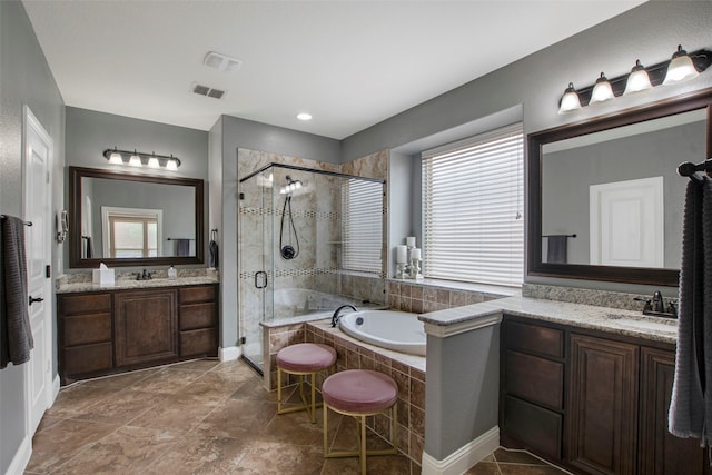 bathroom with a sink, a wealth of natural light, a shower stall, and visible vents