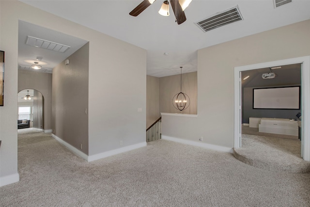 unfurnished room with visible vents, ceiling fan with notable chandelier, and carpet floors
