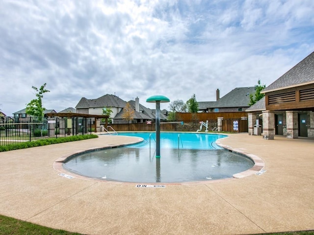 community pool featuring fence and a patio area